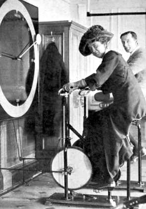Una passeggera si esercita con una delle "biciclette fisse" sotto lo sguardo di Lawrence Beesley.